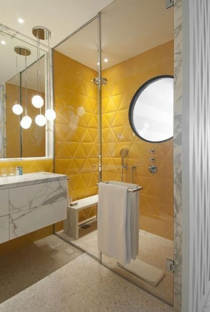 Geometrical shaped yellow wall tiles with marble furniture.